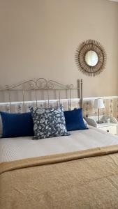 a bedroom with a bed with blue pillows and a mirror at Casa Paloma Blanca in Málaga