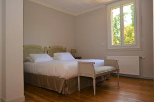 a bedroom with a bed with a chair and a window at La KEFOISE in Fouquières-lès-Lens