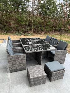 a table with wicker chairs and a tableasteryasteryasteryasteryasteryasteryastery at Vista Karkonosze komfortowe domy z sauną, basenem letnim i opcją jacuzzi in Jeżów Sudecki +23 photos