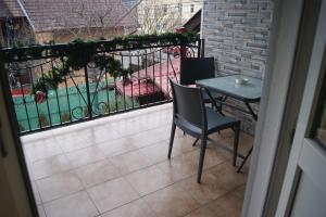 a balcony with a table and chairs and a fence at Pensiunea Monady in Zărneşti