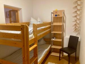 a bedroom with two bunk beds and a chair at Appartement Johanna in Schwarzenberg am Bohmerwald