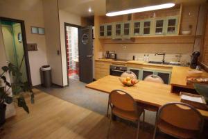 uma grande cozinha com mesa e cadeiras de madeira em BrusselsHomes em Bruxelas