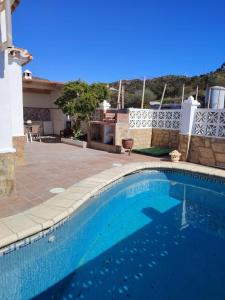 a swimming pool in front of a house at Casa Paloma Blanca in Málaga