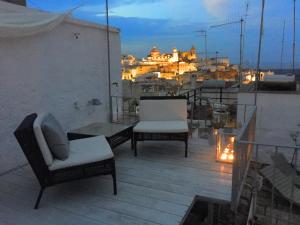a balcony with two chairs and a table and a city at Casa Libertà Spacious white scandidesign in Ostuni