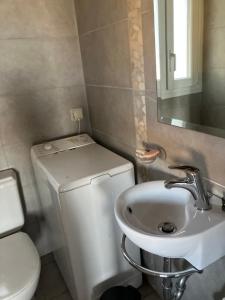 a bathroom with a white toilet and a sink at Sunsetview house in Kakongiónion