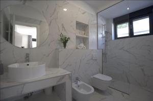 a bathroom with a sink and a toilet and a mirror at Luxury Villa Mandy - Split in Žrnovnica +21 photos