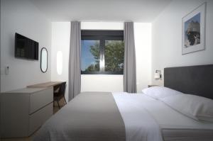 a bedroom with a bed and a desk and a window at Luxury Villa Mandy - Split in Žrnovnica