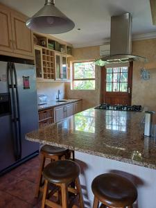 a kitchen with a granite counter top and stools at A Jungle House in Somerset West