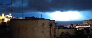 a view of a city at night with a bright light at Casa Libertà Spacious white scandidesign in Ostuni