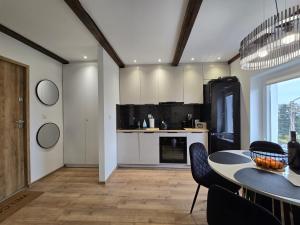 Una cocina con una mesa y un comedor. en Apartament Gołębiewscy, en Boguszów-Gorce