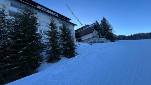 a building in the snow with trees in front of it at Sonnenalpe Nassfeld in 1500 m Höhe an der Skipiste in Sonnenalpe Nassfeld +10 photos
