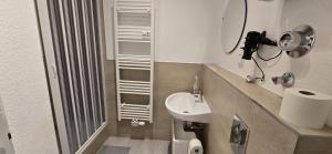 ein kleines Badezimmer mit Waschbecken und Spiegel in der Unterkunft Monteurwohnung Ferienwohnung Krefeld Nähe Düsseldorf 2-4 Personen in Krefeld