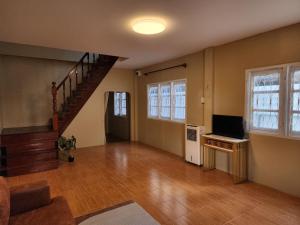 an empty living room with a staircase and a television at Demi house in Nong Khai