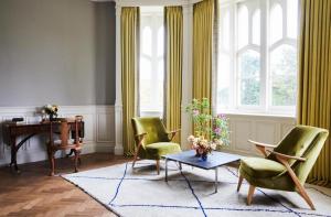 a living room with chairs and a table and a desk at Oakley Court in Windsor