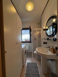 a bathroom with a sink and a toilet and a mirror at Apartament Doge in Sappada +28 photos