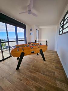 uma mesa de madeira em uma sala com uma prancha de surfe sobre ela em L'Anse des Baleines, Vue panoramique sur l'océan, Piscine & Confort 4 étoiles em Petite Île mais 33 fotografias