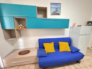 a blue couch with two yellow pillows in a room at Baia Piccola in Baia Verde