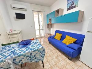 a living room with a blue couch and a table at Baia Piccola in Baia Verde
