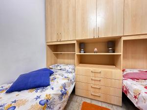 a bedroom with two beds and wooden cabinets at Baia Piccola in Baia Verde
