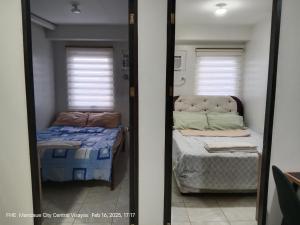 Dos camas en una habitación con dos ventanas. en Lloyds Barato 2BR Condo Unit 6paxMax, en Mandaue