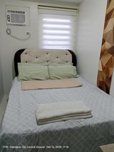 Una cama con dos toallas encima en un dormitorio. en Lloyds Barato 2BR Condo Unit 6paxMax, en Mandaue