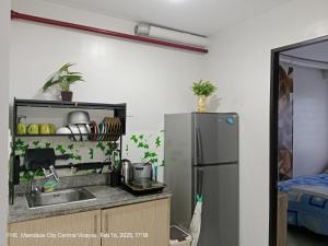 a kitchen with a sink and a refrigerator at Lloyds Barato 2BR Condo Unit 6paxMax in Mandaue City