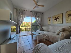 イスランティージャにあるCasa adosada en el campo de golf de Islantillaのリビングルーム(ソファ付)が備わり、パティオの景色を望めます。