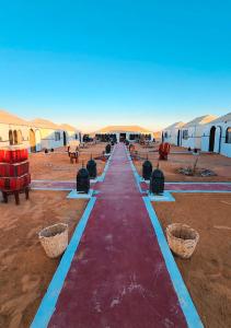 a long red carpet in the middle of the desert at Nour Desert Luxury Camp in Merzouga