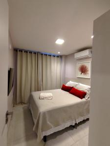a bedroom with a bed with two red pillows at Porto BLUE 05 térreo Centro de Porto de Galinhas in Porto De Galinhas