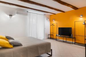 una camera da letto con un letto e una TV a schermo piatto di Tra i vicoli di Napoli, La Olivella design e amore a Napoli