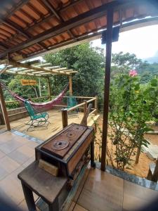 a wood stove on a patio with a hammock at Cantinho do Ipê Alto Caparaó MG in Caparaó Velho