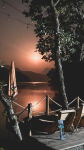 a view of a lake with a tree and a bench at Tropical Escape - Patal Eco Villas in Rānīpauwa