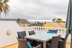 a patio with a table and chairs on a balcony at Vila Van Gogh in Luz