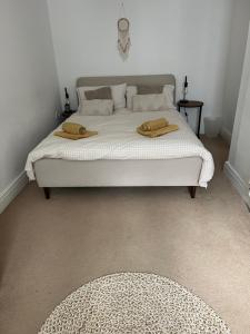 ein Schlafzimmer mit einem Bett mit zwei Handtüchern darauf in der Unterkunft Old Stable Cottage in Alnmouth