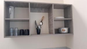 a wooden shelf with utensils on a wall at MJ homes in Mtwapa