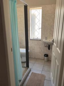 a bathroom with a shower and a toilet and a sink at Crescent accommodation in Klerksdorp +13 photos