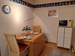 a room with a table and a microwave and a clock at Birkenweg 3 Apartment in Büchen