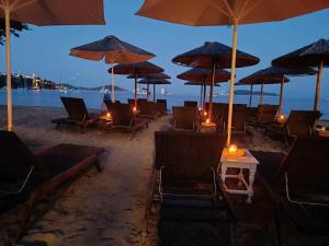 a group of chairs and umbrellas on a beach at Physis Oikos Beachfront Apartments in Skiathos