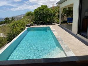 a swimming pool in the backyard of a house at Leu Panoramique in Saint-Leu
