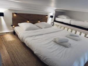 un grande letto bianco con due asciugamani sopra di Cannes Croisette Festival Plage Mer a Cannes