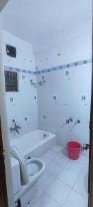 a bathroom with a tub and a toilet and a sink at Mahuri home stay in Visakhapatnam