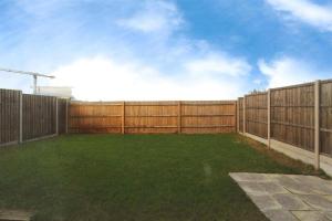 GreenhitheにあるFamily Friendly 4-Bedroomsの塀と緑草の裏庭