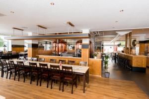 a restaurant with a long dining table and chairs at Landhotel Butjadinger Tor in Nordenham