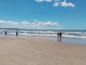 a group of people walking on the beach at Cabaña Faro di luce in Santa Vitória do Palmar +1 photo