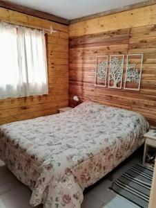 a bedroom with a bed with wooden walls at Cabaña Faro di luce in Santa Vitória do Palmar