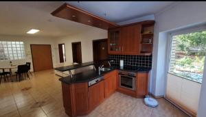 a kitchen with wooden cabinets and a table in it at Zimmer am See mit Zugang in Zeuthen +3 photos