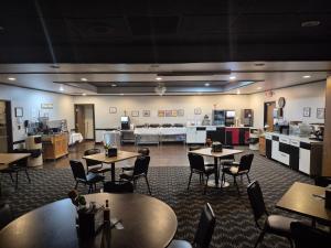 a restaurant with tables and chairs in a room at Abilene Whitten Inn in Abilene