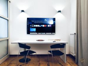 サレルノにあるSalerno Place - Design Houseの白い机と椅子、そして壁に掛けられたテレビ