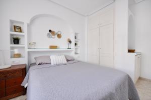 biała sypialnia z łóżkiem i białymi szafkami w obiekcie CB Living - Cozy condo with patio, Playa Flamenca w mieście Orihuela Costa