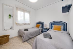 sypialnia z dwoma łóżkami i lustrem w obiekcie CB Living - Cozy condo with patio, Playa Flamenca w mieście Orihuela Costa